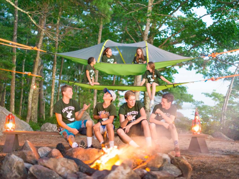 campers hanging out in front of a fire