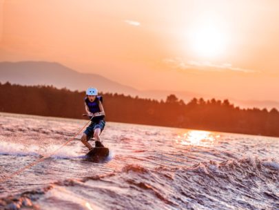 camper wakeboarding at sunset