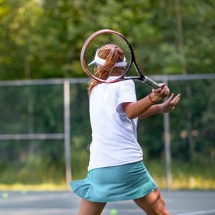 young girl swinging a tennis racket