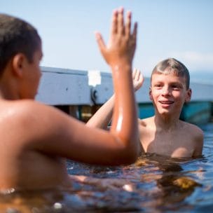 boys in water about to high five