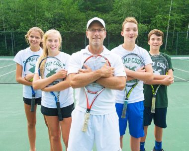 tennis coach and four students at his sides