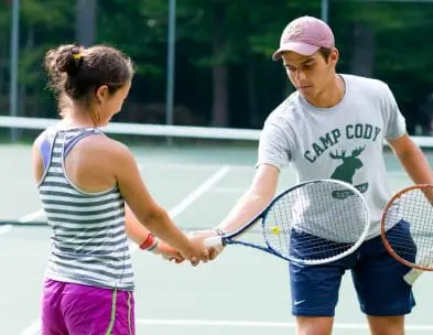 an instructor correcting the hand position of a young girl