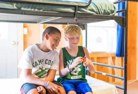 two boys on a bed solving a rubix cube