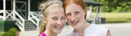 two girls with braces smiling