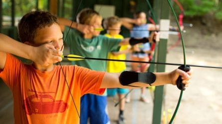 young campers preparing to shoot a bow and arrow