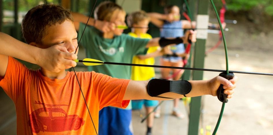 young campers preparing to shoot a bow and arrow