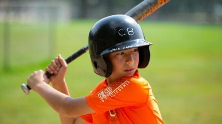 young boy with a baseball bat ready to swing