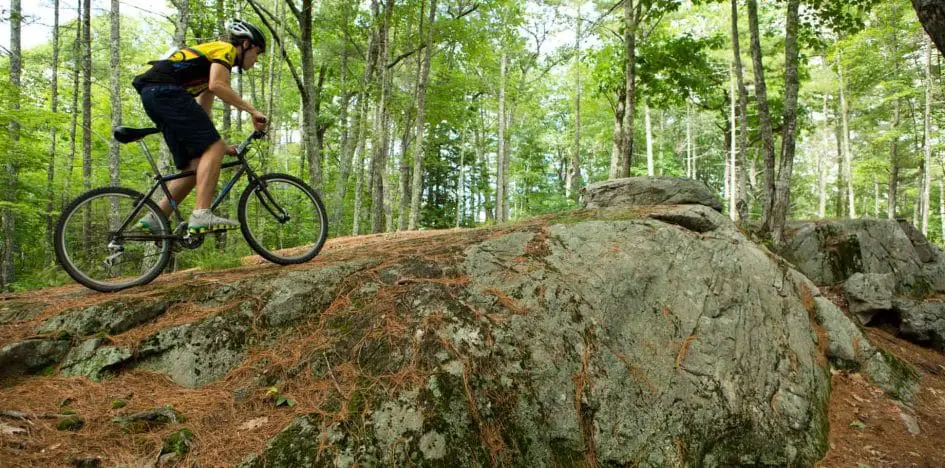 boy biking up a rock