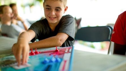 boy reaching for a card in the game of sorry