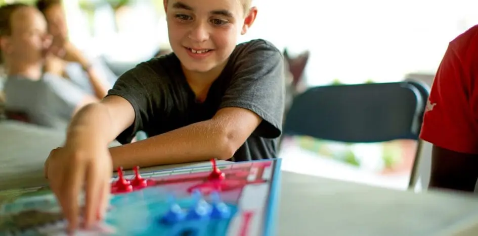 boy reaching for a card in the game of sorry