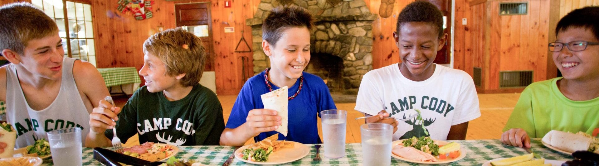 a group of boys eating at a table together