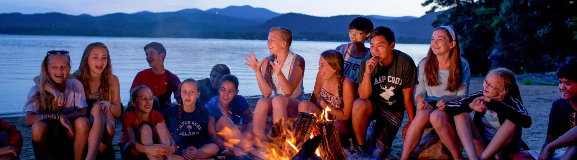 campers smiling around a campfire