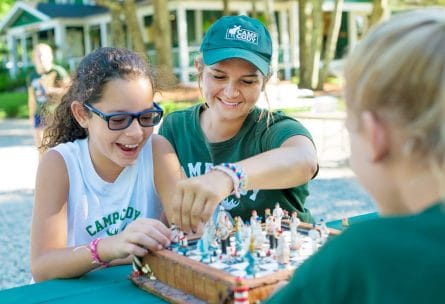 counselor and camper playing chess