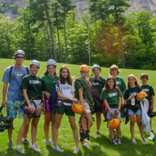 young of campers and instructors with rock climbing gear