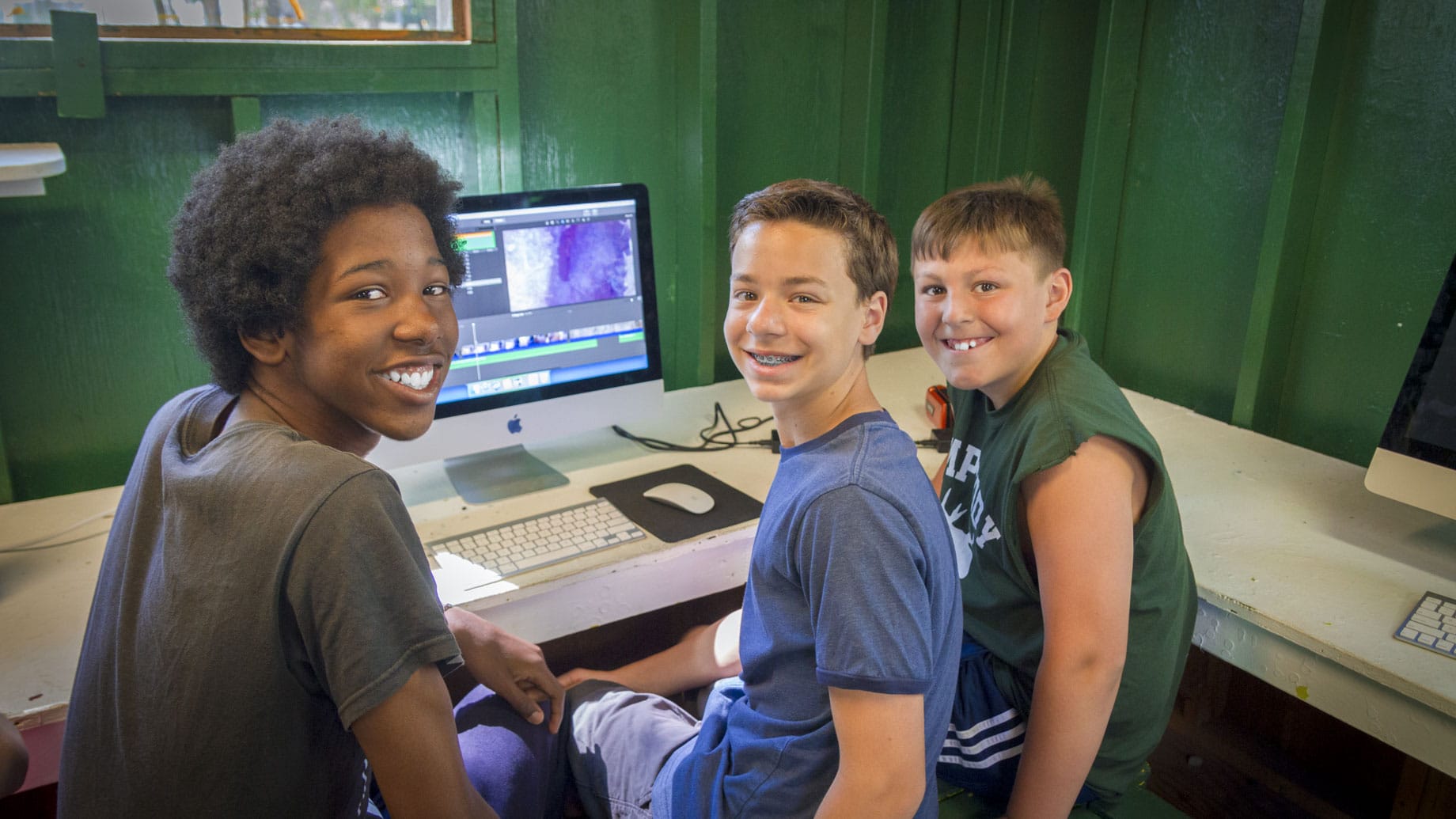 three boys in front of a computer