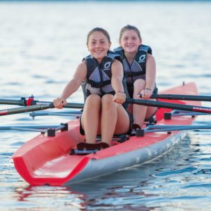 two girls smiling while they row