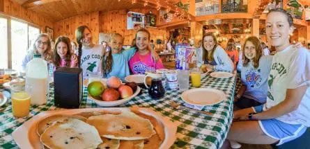 girls and counselors at the dining table