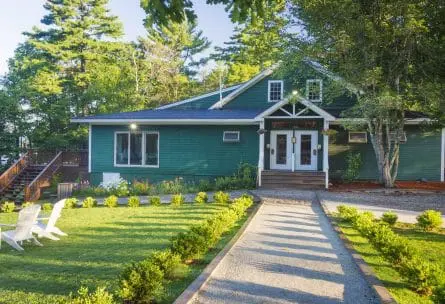 green building with a lawn and lawn chairs