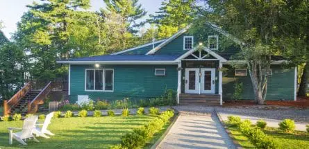 green building with a lawn and lawn chairs