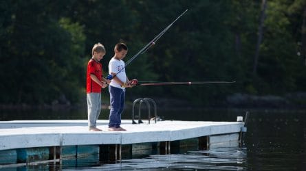two young boys fishing on a pier