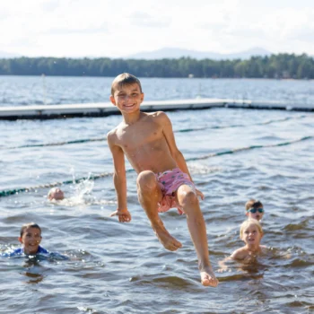 boy jumping into lake.