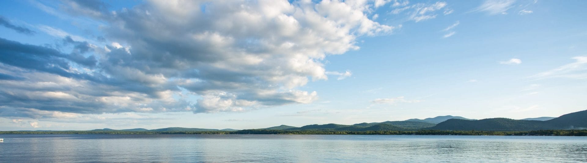 a partially cloudy and beautiful sky over a pristine lake