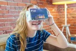 young girl looking at a camp cody virtual reality kit box