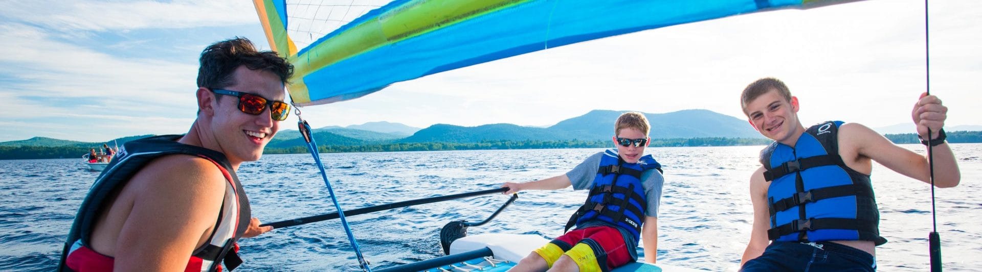 three boys relaxing on a sailboat