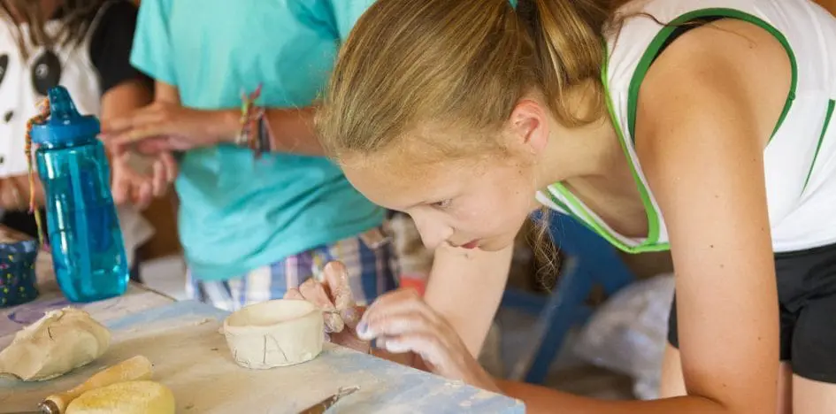 young girl sculpting a pot