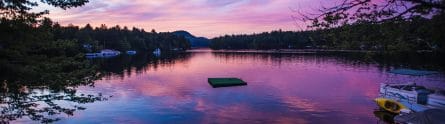 a beautiful purple sunset over a pristine, calm lake