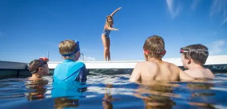 boys staring at an instructor showing how to dive