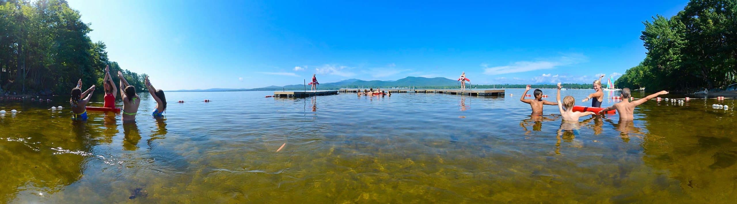 swim instructors showing kids how to swim at a lake