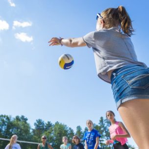 girl tossing a beach volleyball