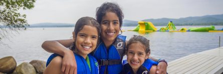 three girls with life vests on smiling