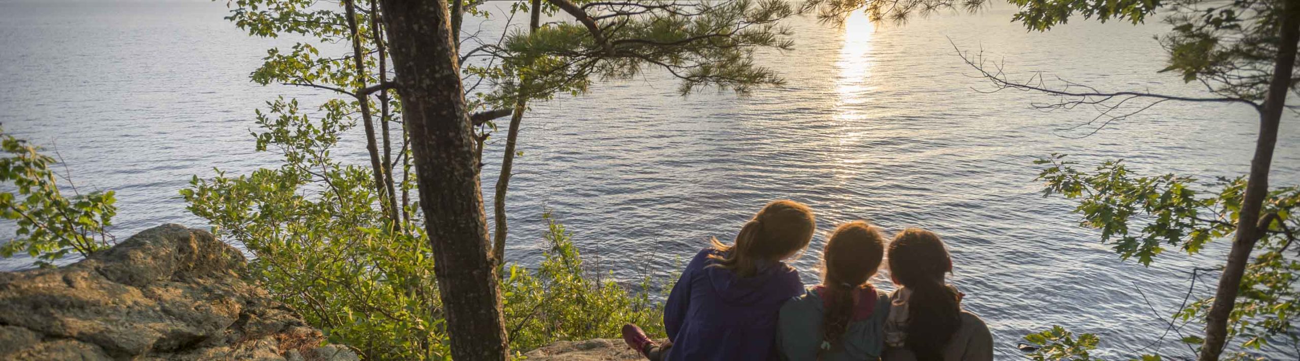 three girls by the lake at sunset