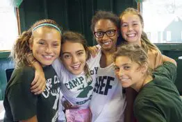 group of 5 girls hugging and smiling at camera