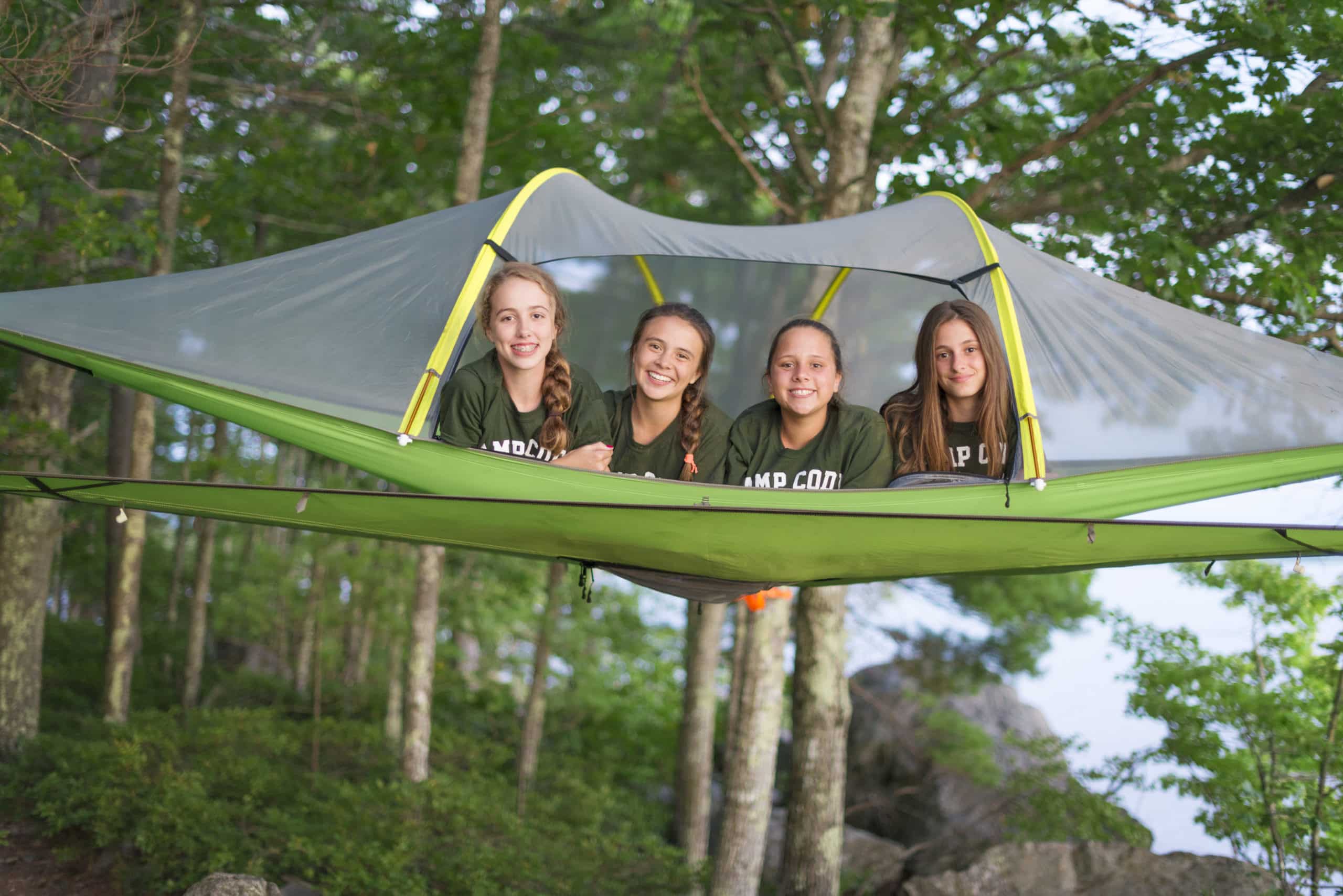 4 girls on a tent in the woods