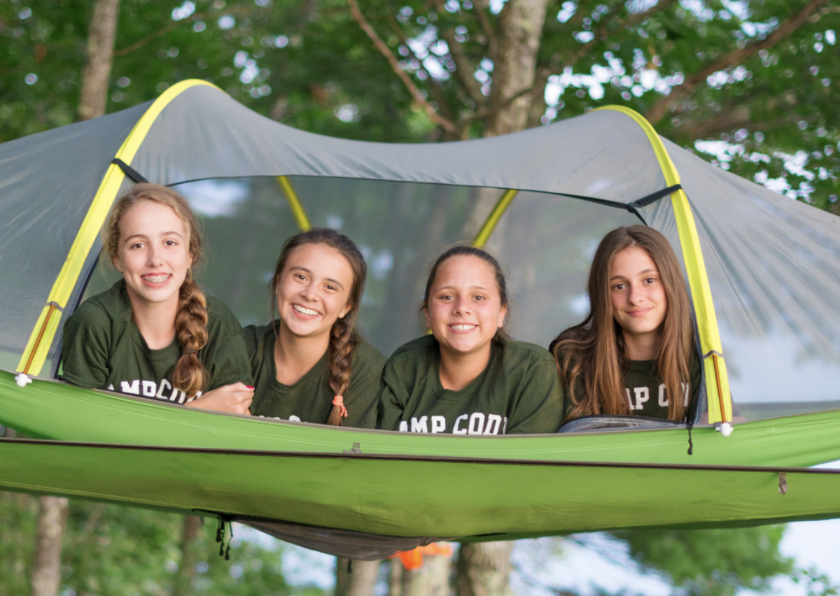 4 girls on tent in the woods