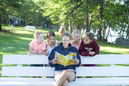 girl reading to campers