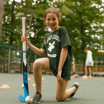 girl playing field hockey.