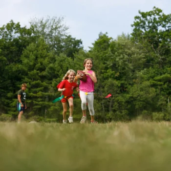 two girls playing flag football.