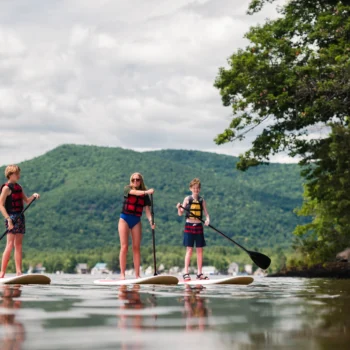 teens paddleboarding on a lake.