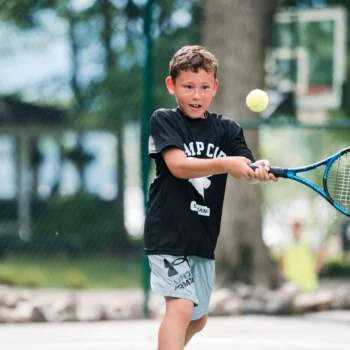boy returning tennis volley.